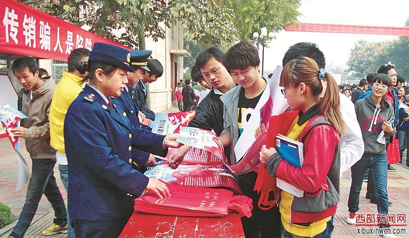 图1:工商人员向学生发放打传宣传资料,引导他们远离传销。