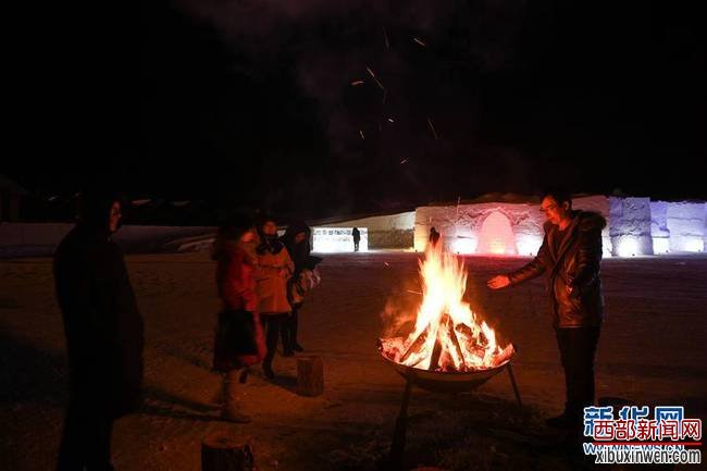 12月24日，在内蒙古根河市敖鲁古雅鄂温克民族乡，游客在冰雪建筑前的篝火边取暖。当日，第五届中国冷极节在内蒙古自治区根河市开幕。根河市素称“中国冷极”，当地利用冰雪资源，并结合独特的鄂温克民族风情，打造冬季旅游项目，为游客带来不一样的冰雪体验。新华社记者刘磊摄